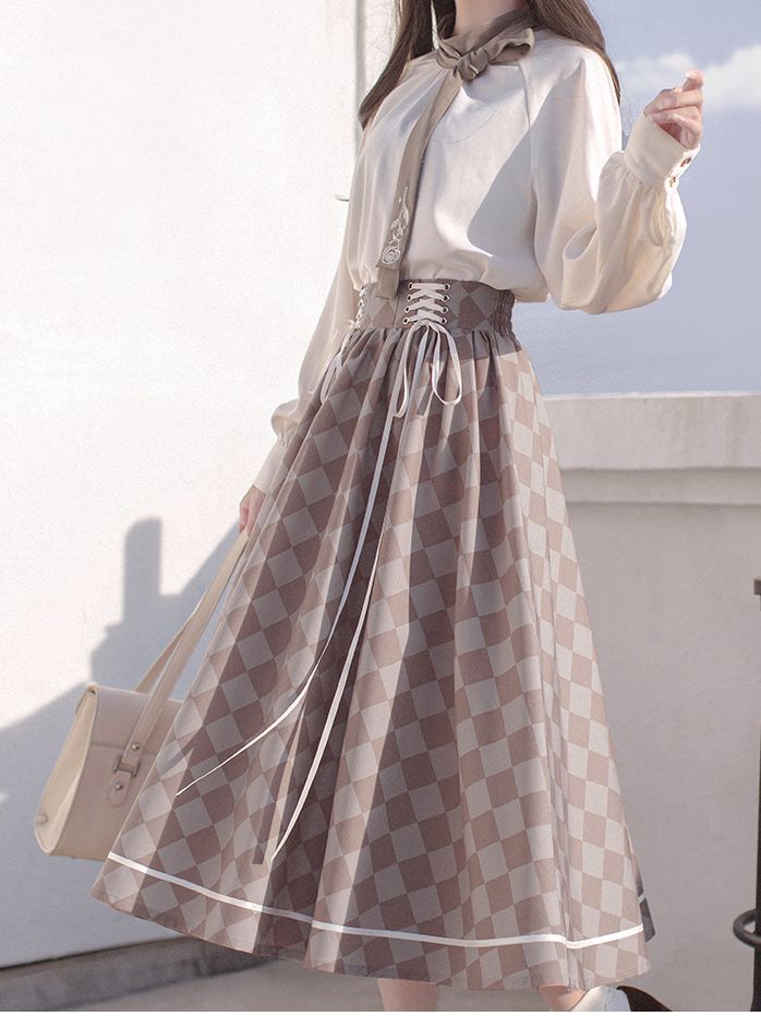 a woman is standing outdoors, modeling a stylish outfit. she's wearing a white, longsleeved blouse with a tie neck and a brown and white checkered skirt. the skirt is highwaisted and features a laceup front detail. she's carrying a lightcolored purse. the image is welllit with natural light, highlighting the details and textures of the clothing. the perspective is at eye level, providing a clear view of the complete outfit.