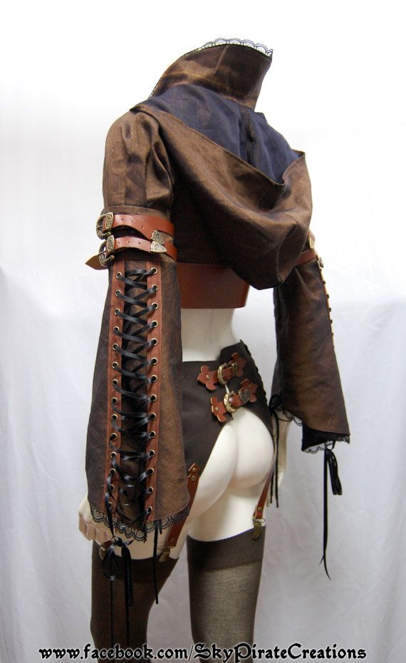 a woman wearing a steampunk cosplay costume. the costume is made of brown leather and includes a corset, garter belt, stockings, boots, and a leather jacket. the woman is posing with her back to the camera and her hands on her hips. the costume is decorated with buckles, metal accents, and lace.