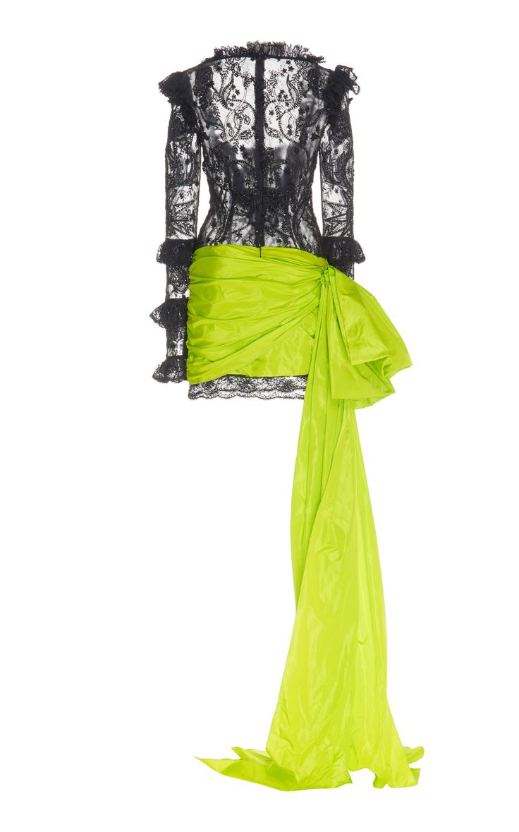 this is a black lace, longsleeved mini dress with ruched green satin skirt that has a dramatic bow and long train.  the floral lace is intricate and beautiful. the dress is styled on a model, and the overall look is very high fashion and elegant.
