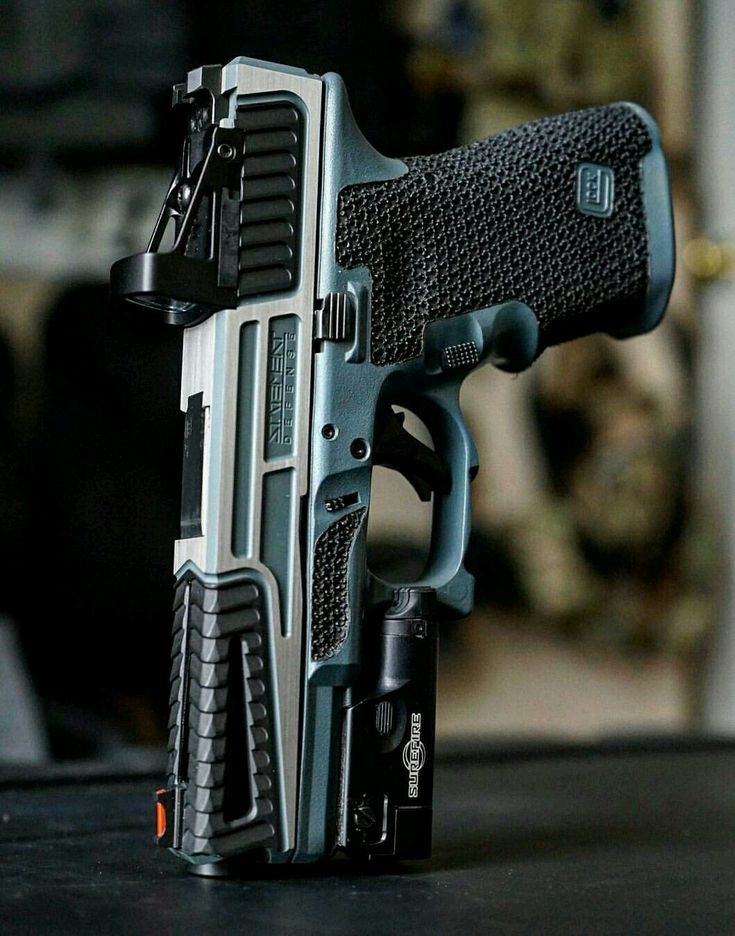 a customized glock handgun with a statement defense slide, stippled grip, surefire weapon light, and red dot sight.