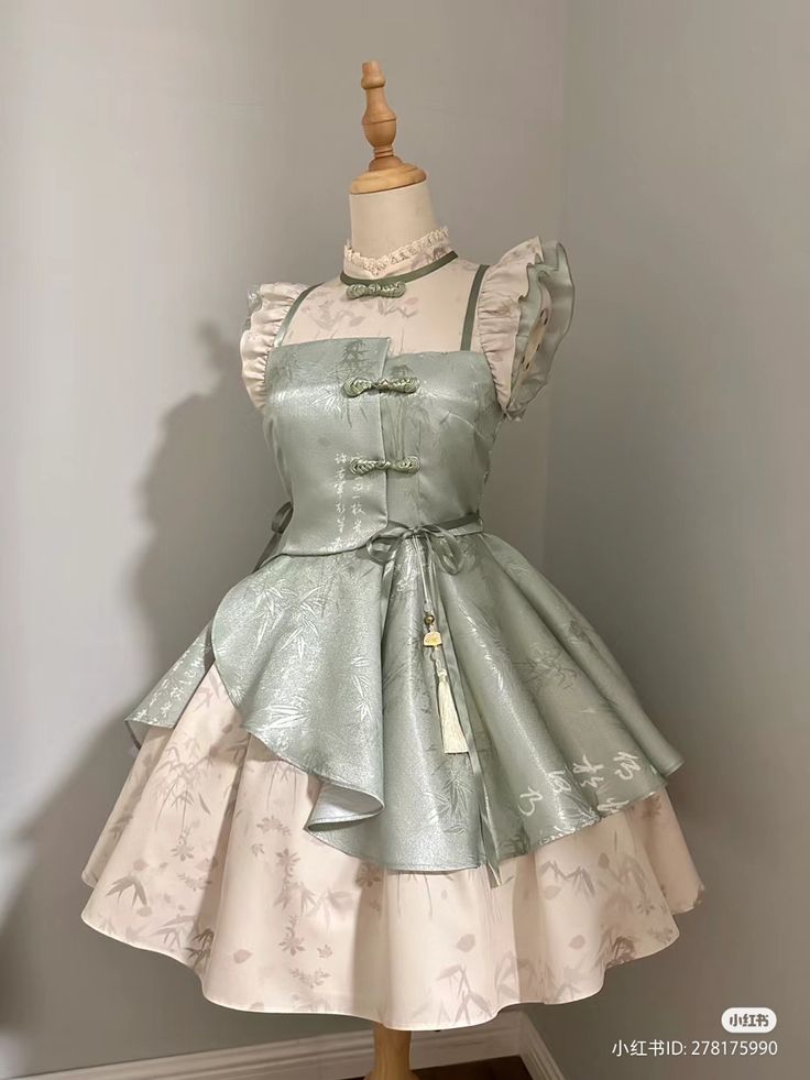 a green and white lolita fashion dress with chinese style elements. the dress has a high collar, short sleeves, and a flowing skirt. it is decorated with floral patterns and chinese characters. the dress is displayed on a mannequin.