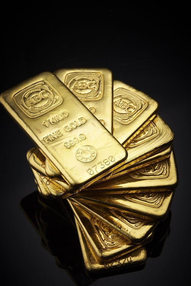 the image showcases a stack of gleaming gold bars set against a stark black background. each bar, reflecting the studio lighting, bears the inscription "1 kg fine gold 999.9" and a unique serial number.  the arrangement of the bars, fanned out slightly, emphasizes their weight and value.