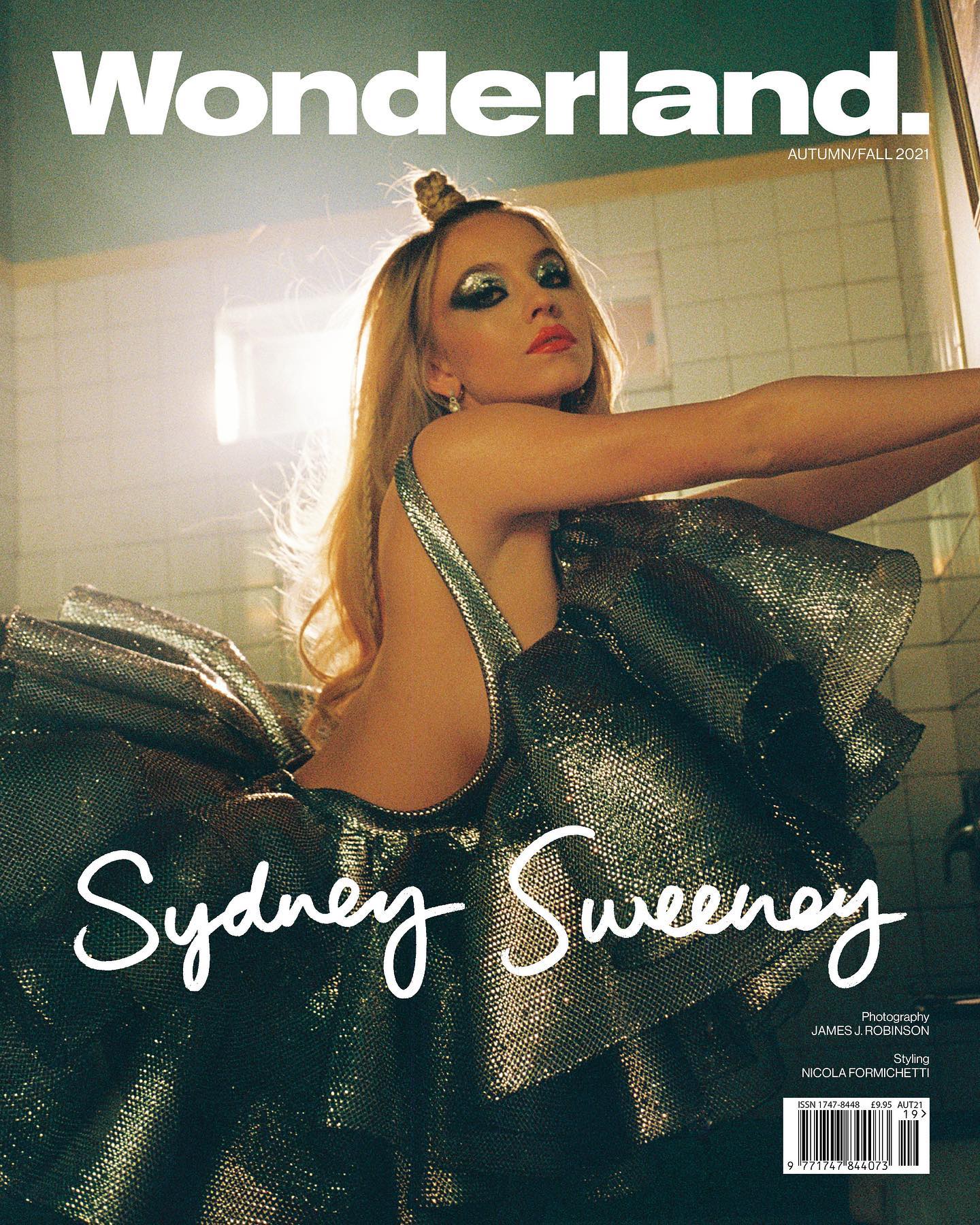 he cover of wonderland magazine, autumn/fall 2021, features sydney sweeney.  she is prominently displayed in a dark green, metallic, ruffled dress. her makeup is striking, and her hair is styled in a topknot.  the background is a vintagestyle bathroom with tiled walls. the overall aesthetic is glamorous and retro.  the photographer is credited as james j. robinson, and the stylist as nicola formichetti.