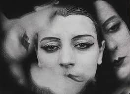 the image is a striking black and white photograph, likely a double exposure, depicting the face of a woman. the style is distinctly surreal, with the woman's face partially obscured and overlaid with what appears to be another image of a face or a shadowed figure, creating a sense of depth and mystery.  her expression is ambiguous, somewhere between sadness and contemplation. the dark background and use of shadow enhances the dramatic and somewhat melancholic atmosphere. the overall aesthetic suggests a vintage feel, possibly from the early to mid20th century, reminiscent of the work of man ray or other surrealist photographers. the image is highly artistic and leaves much to the viewer's interpretation.