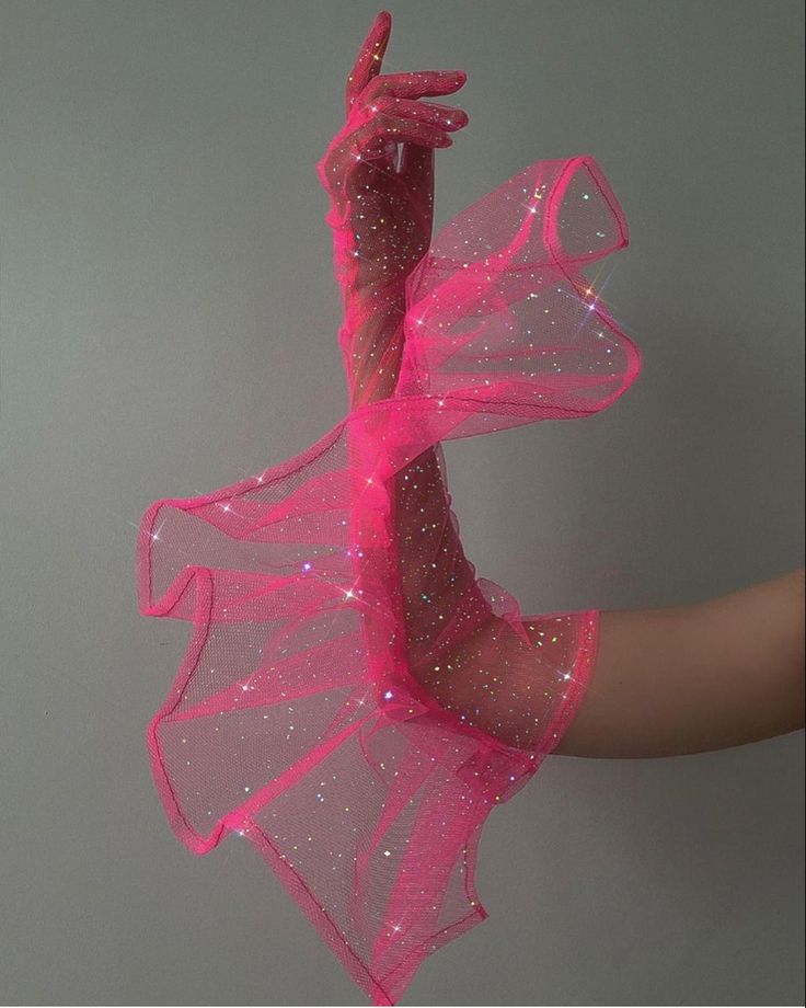 a pair of pink glitter mesh gloves are shown in the photo. the gloves are covering the hands of a person, only their arm is visible. they have a very feminine, sparkly, and glamorous look.  the gloves are perfect for a special occasion or party.