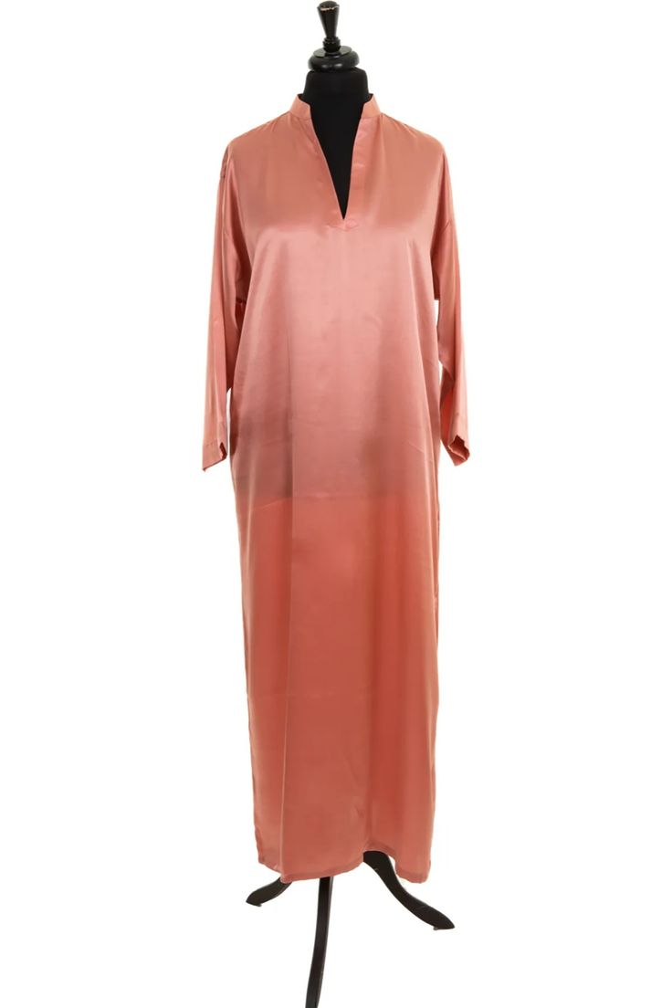 a pink longsleeved dress with a high collar on a mannequin. the dress is silky smooth and has a slightly flared skirt. the mannequin is on a simple black stand.