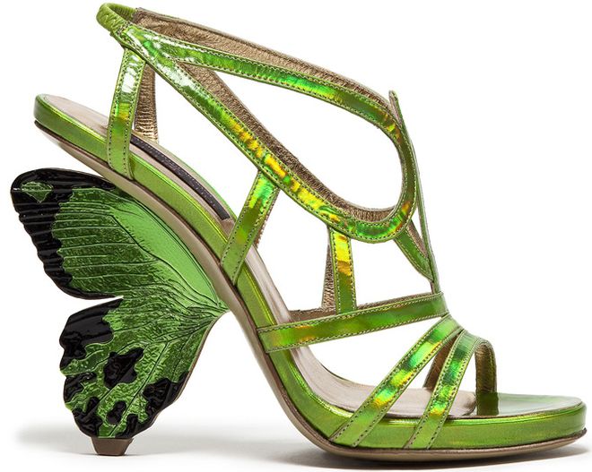 the image shows a single, elegant green highheeled sandal.  the striking feature is the large, iridescent green butterfly wing forming the heel of the shoe. the sandal itself is a caged style with multiple straps,  constructed from a shiny, possibly metallic, green material.  the shoe has a slender, stiletto heel and is clearly a fashionforward, statement piece.