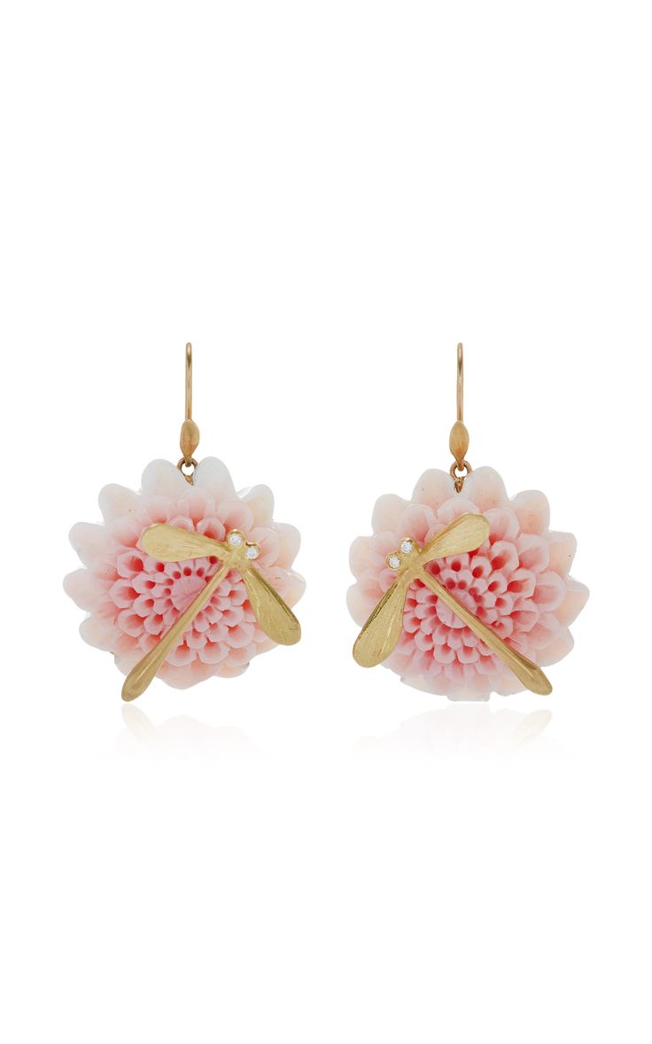 a pair of delicate gold earrings featuring pink flower blossoms adorned with a gold dragonfly design. the earrings have a feminine and whimsical aesthetic, perfect for adding a touch of elegance to any outfit.
