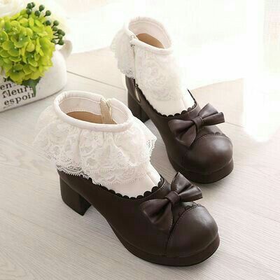 a pair of brown lolita platform shoes with white lace trim and bows.