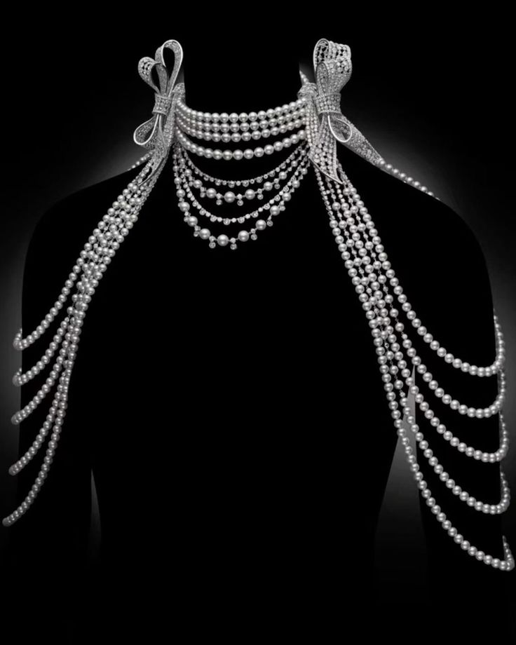 an image of a mannequin wearing an elaborate pearl necklace with diamond bow accents on a black background. the necklace consists of multiple strands of pearls of varying lengths, draped around the neck and shoulders. the diamond bows are situated on either side of the neck, adding a touch of luxury and sophistication to the piece. the pearls appear luminous against the dark backdrop, highlighting the intricate design and craftsmanship of the jewelry.