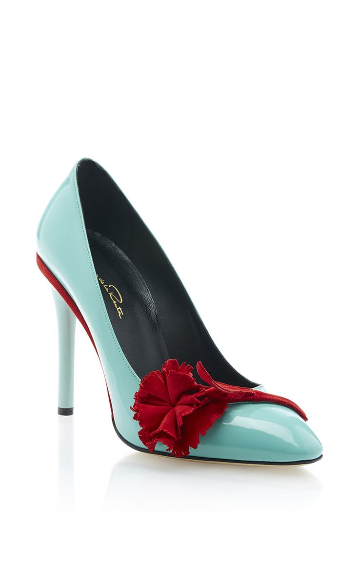 a highheeled, turquoise patent leather pump with a red stiletto heel and a red ruffled embellishment near the toe.