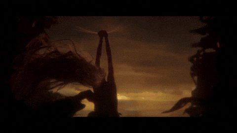 the image shows a dark and ominous scene. silhouetted against a sunset sky, a strange creature stands with its arms raised. it appears to be a monster or some type of horrific fantasy being with tentacles or other appendages. the overall impression is one of fear and foreboding.