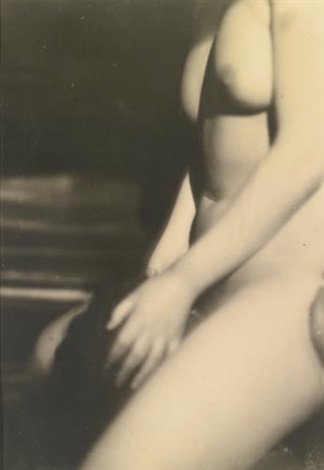 a black and white photograph of a nude female torso and legs. the image is softly focused, creating a dreamy and sensual atmosphere. the model's body is partially visible, with her hand resting on her thigh. the background is dark and indistinct, drawing attention to the figure. the overall tone is intimate and suggestive.