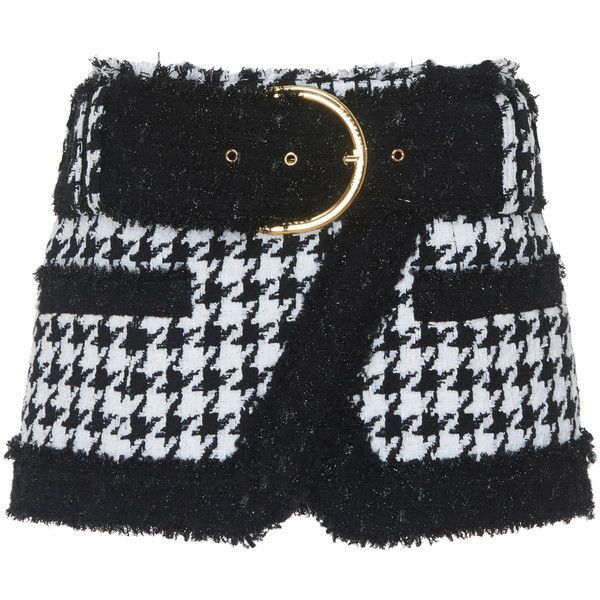 a black and white houndstooth skirt with a black belt and gold buckle. the skirt has fringe along the bottom and a pocket on each side.