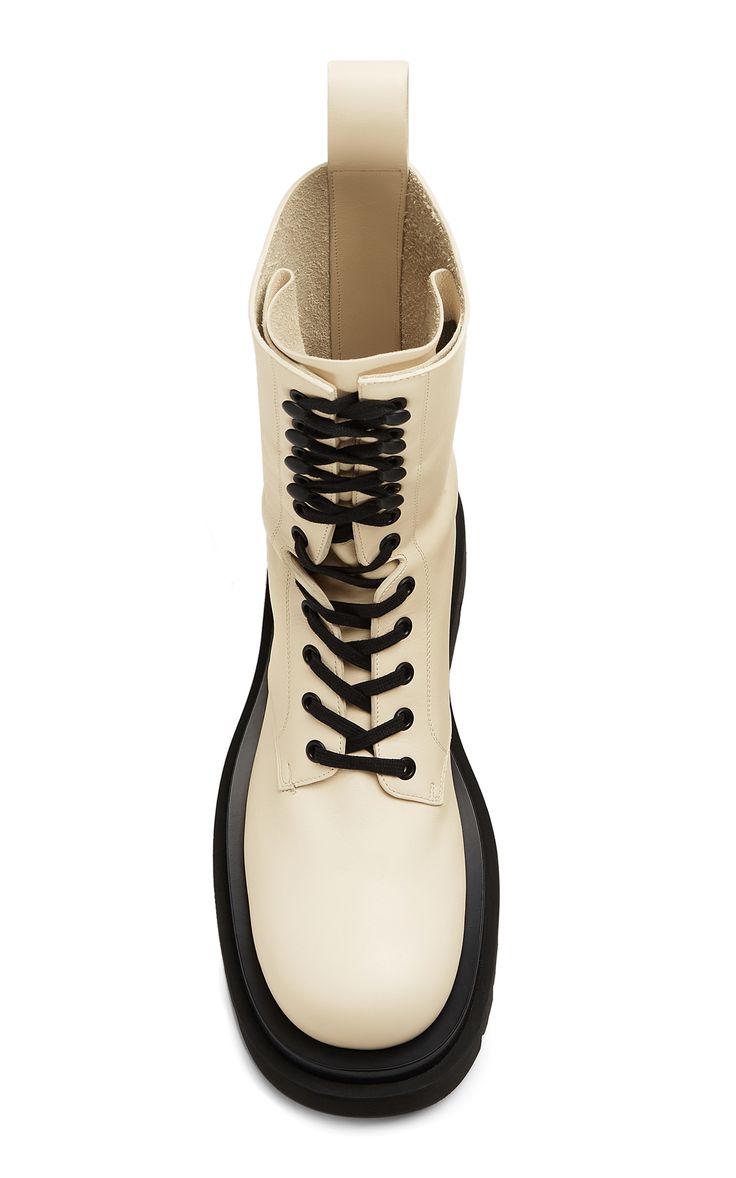 a topdown view of a pair of beige leather platform laceup boots. the boots have a chunky black sole and are tied with black laces. the leather appears smooth and the overall style is casual yet trendy.