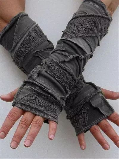 a closeup photo of a man wearing a pair of grey knitted arm warmers with ripped detailing. the warmers are covering his hands and wrists, and the man's hands are showing through the ripped areas. the warmers are a casual and stylish accessory that would be perfect for colder weather.