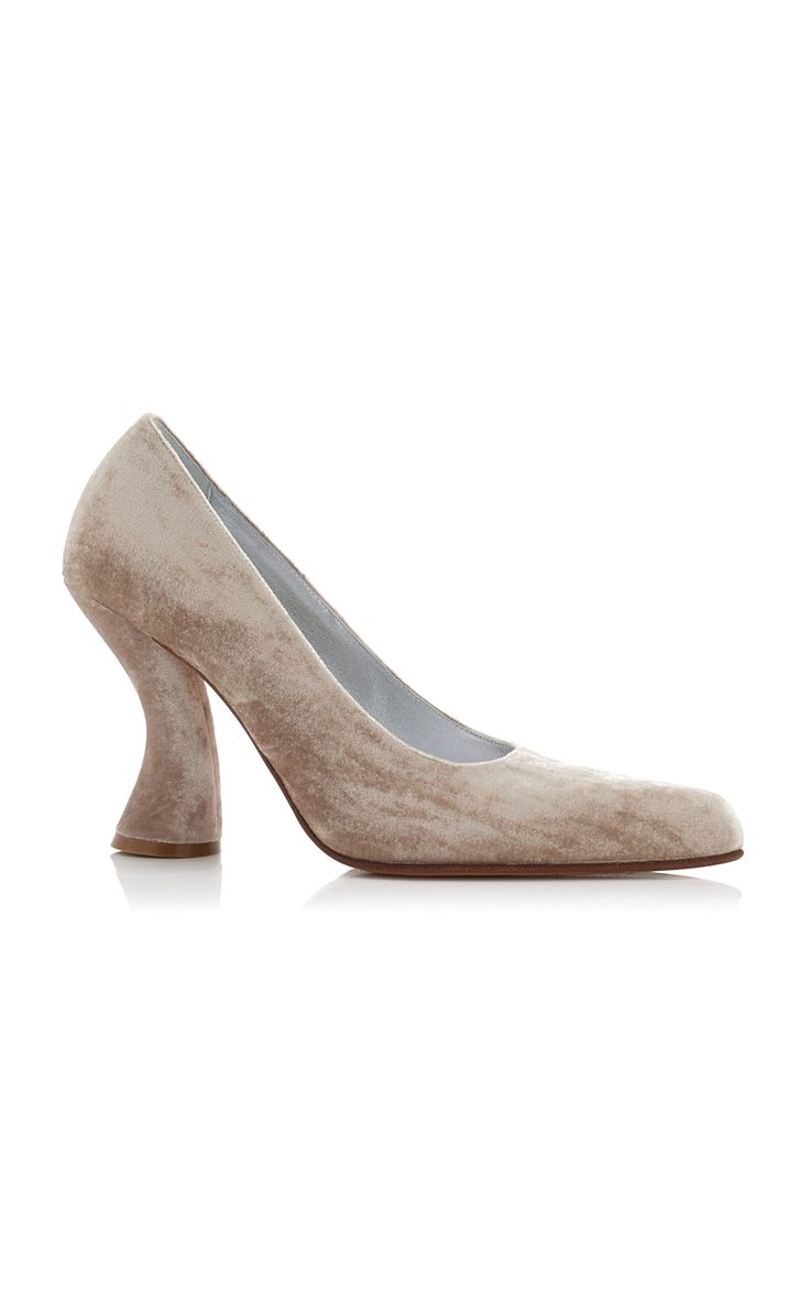 a pair of beige velvet highheeled pumps. the shoes have a square toe and a thick, sculpted heel.
