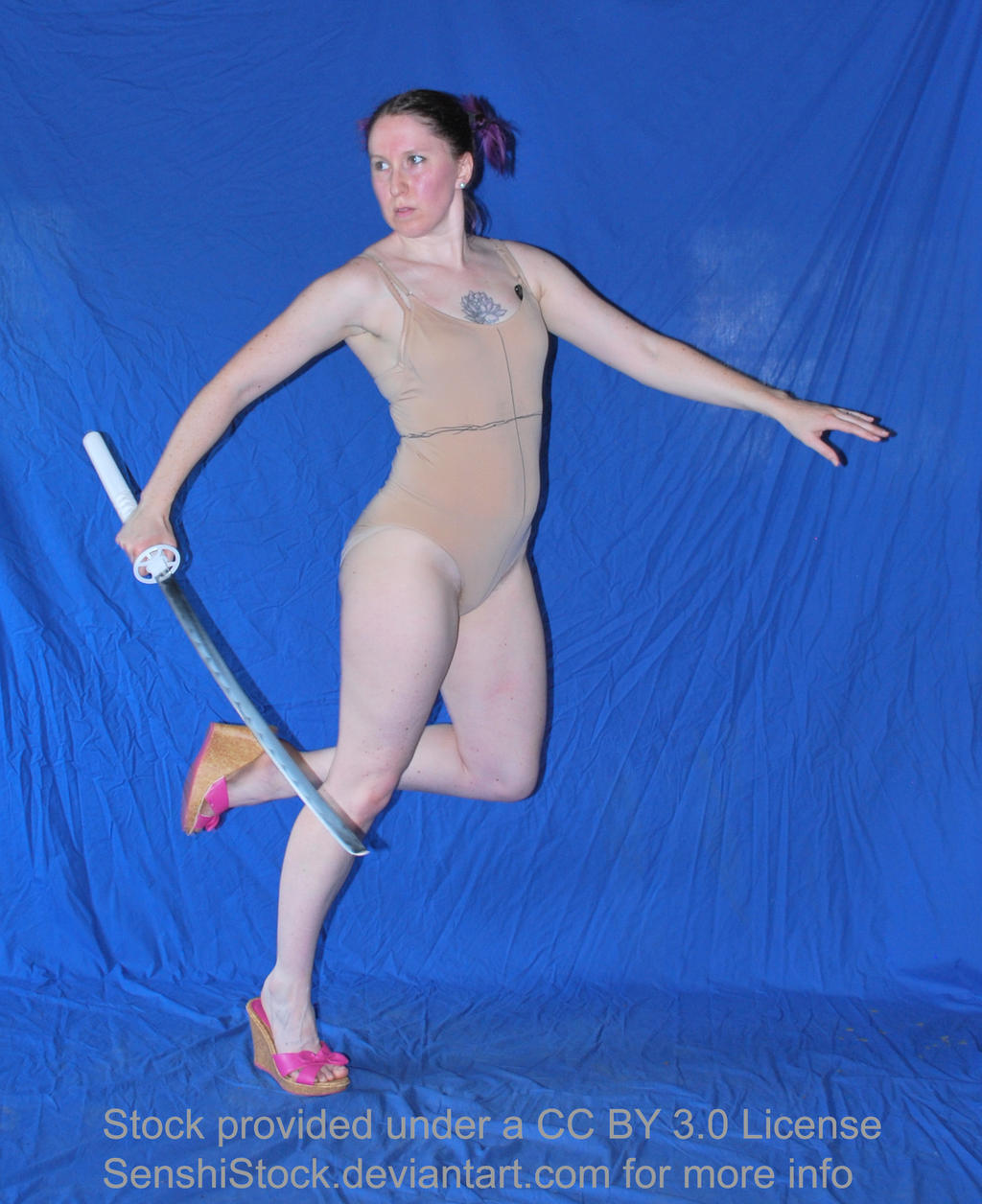 the image shows a woman in a nudetoned leotard and pink wedge shoes holding a katana. she is posed dynamically, as if in midaction, against a bright blue backdrop. the setting appears to be a studio.  the woman has purple hair pulled back. the image is explicitly identified as stock photography under a creative commons by 3.0 license from senshistock.  the pose is suitable for reference in art or animation.