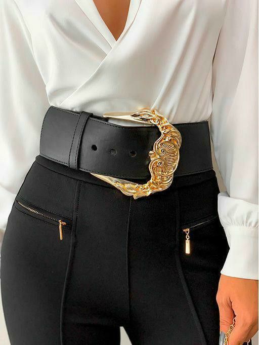 a woman is wearing a white blouse and black highwaisted pants with a wide black belt featuring an elaborate gold buckle. the pants have visible zipper pockets with gold pulls. the focus is on the woman's midsection and the stylish combination of the blouse, belt, and pants.