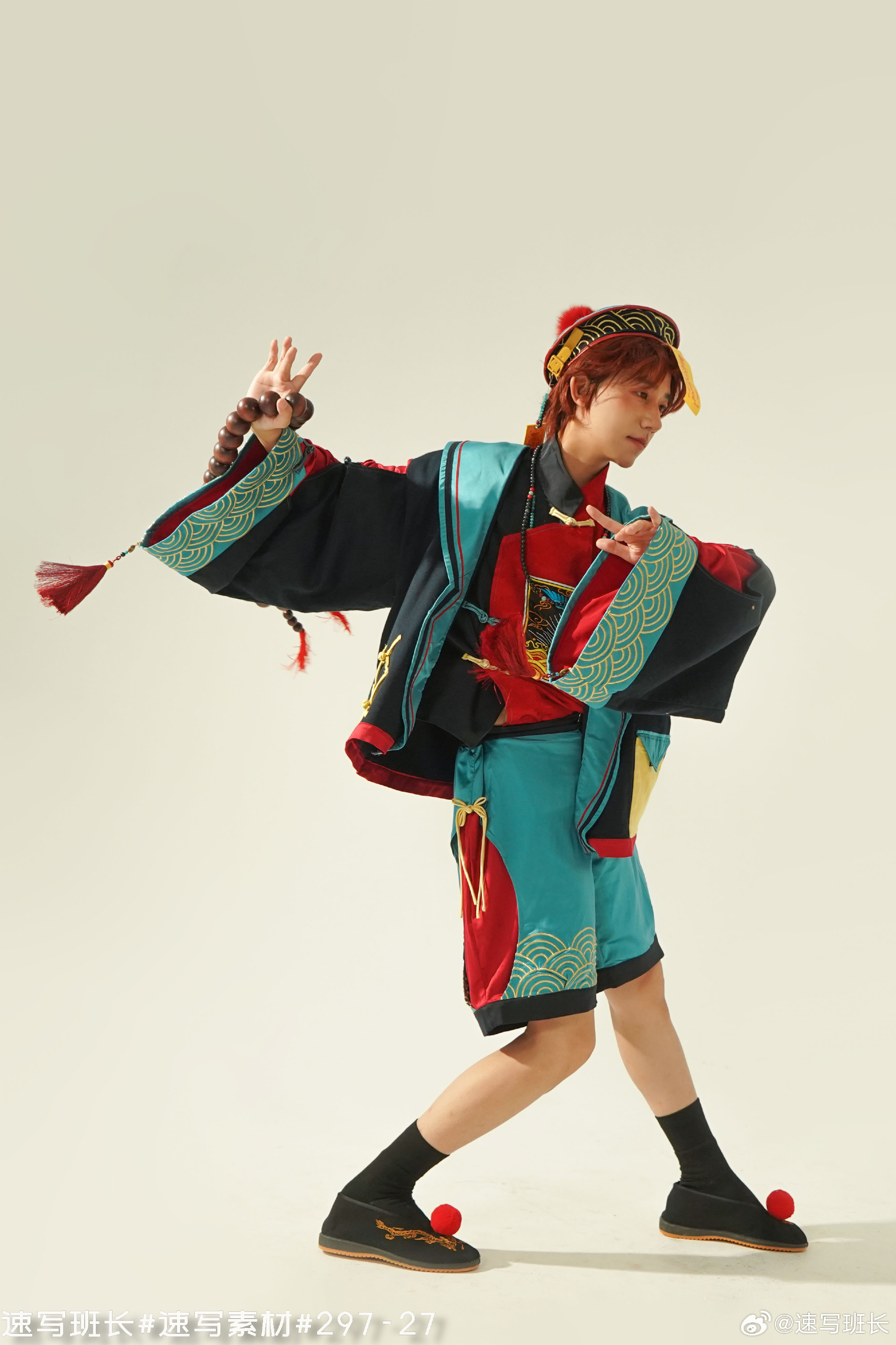 the image features a person in a cosplay of hu tao from genshin impact, posing against a white background. the costume is detailed and vibrant, showcasing the character's signature black, red, and teal color scheme. the individual is striking a dynamic pose, highlighting the fluidity and energy of the character. the studio lighting emphasizes the details of the costume and creates a sharp contrast against the background.