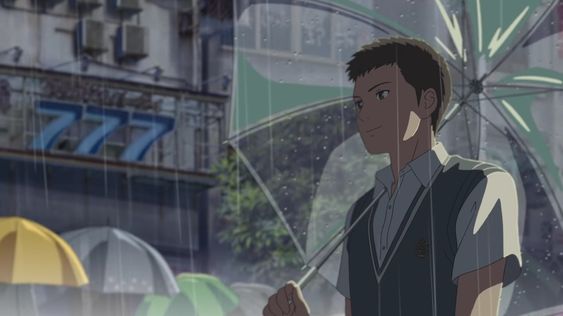 a young man in a school uniform stands slightly offcenter in the image, holding a transparent umbrella with a green and white design. he's looking off to the right with a thoughtful expression on his face. rain is falling heavily in the background, blurring the cityscape of buildings and signs behind him. the dominant colors are muted blues, grays, and greens, creating a contemplative and atmospheric mood.