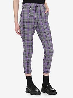 a person wearing gray and purple plaid pants. the person is also wearing black socks and black shoes.