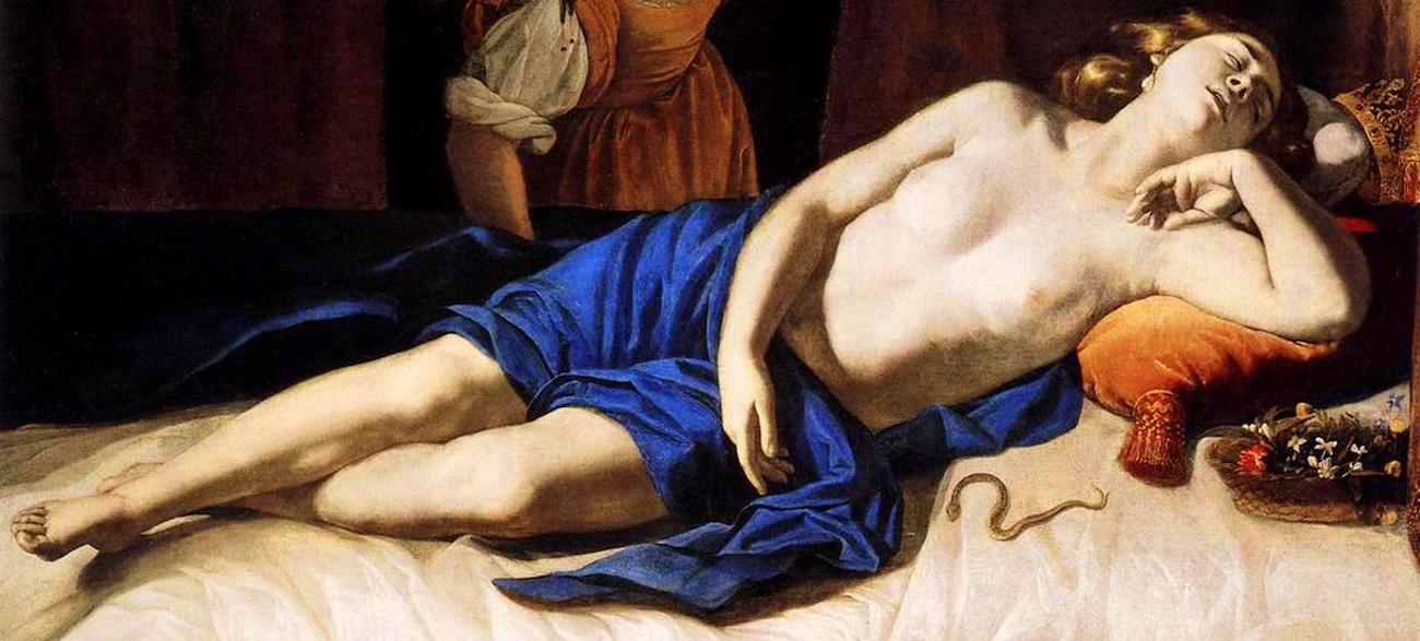 the painting depicts a nude woman, identified as cleopatra, lying on a bed covered with white sheets and a blue cloth. she is asleep, with her head resting on an orange pillow. next to her is a snake, a basket of flowers and fruit, and a crown. an attendant stands behind her. the painting is an allegory of cleopatra's death by snake bite.