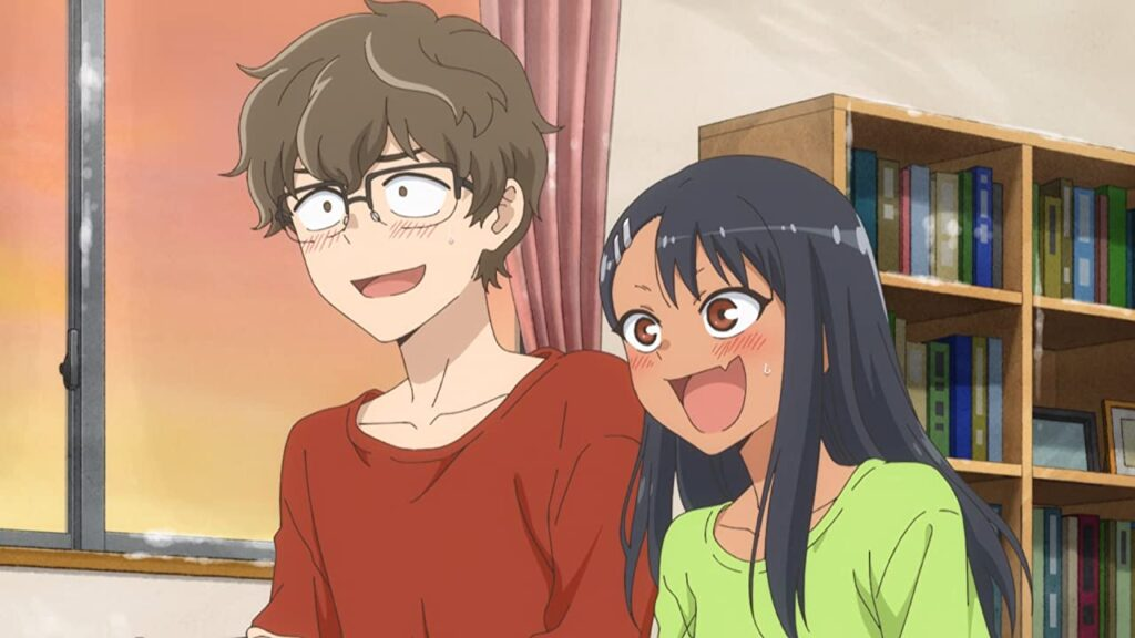 a young man and woman are depicted in what appears to be a living room setting. the man, wearing glasses and a red shirt, has an exaggeratedly surprised and happy expression. the woman, with long black hair and a green shirt, has a similar expression with blushing cheeks. behind them is a window showcasing a snowy scene and a bookshelf filled with books. the overall atmosphere is lighthearted and playful.
