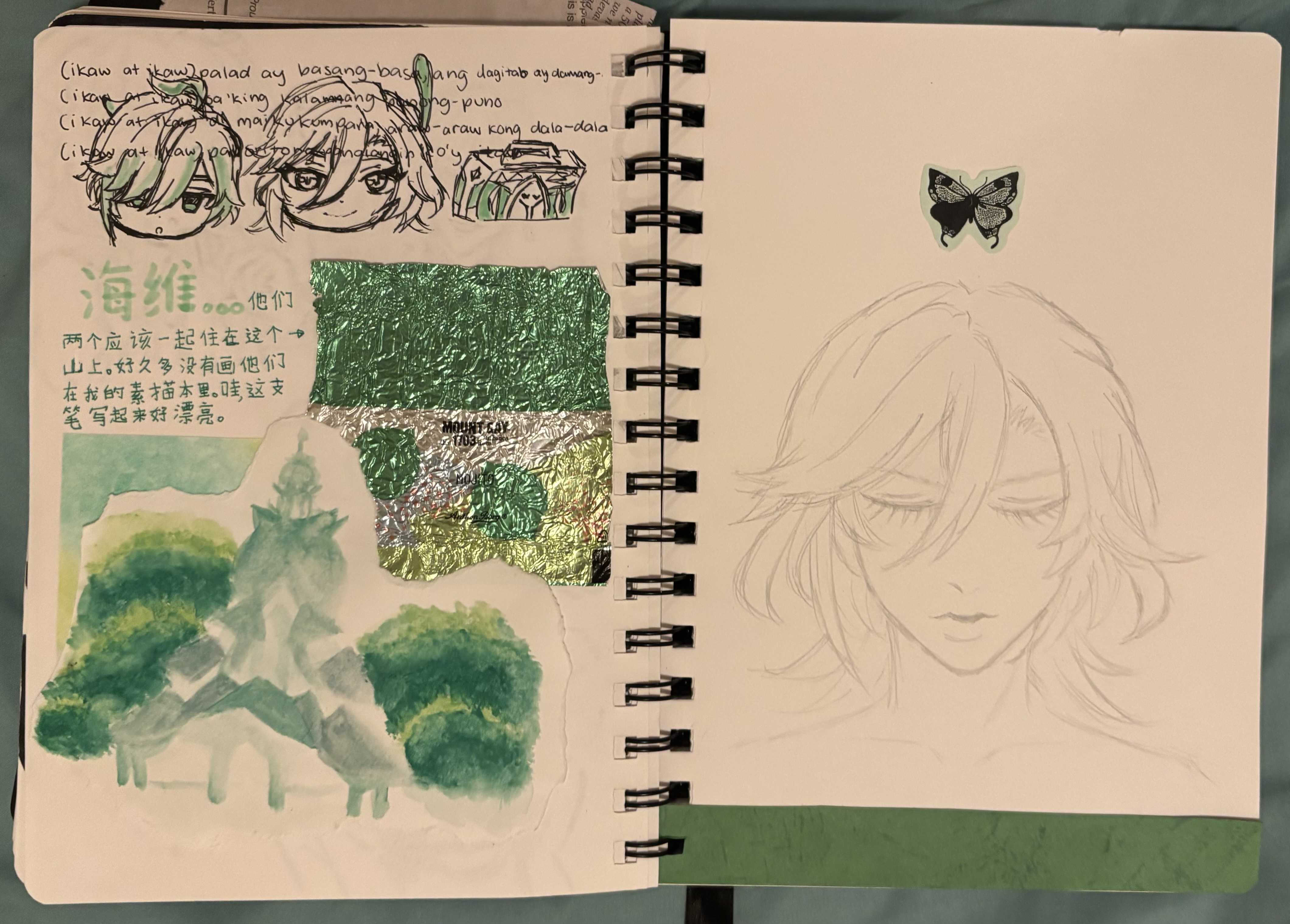 the image is of an open sketchbook with sketches, watercolor painting, a foil collage, and handwritten notes. on the left page, there are animestyle character sketches, handwritten notes in filipino and chinese, a watercolor painting of a landscape featuring trees and a mountain, and a collage made of green and silver foil. the right page contains a pencil sketch of an anime character's face with a butterfly sticker placed above it, and a green tape on the bottom. the overall theme seems to revolve around a green color palette and a mix of different art mediums and languages.