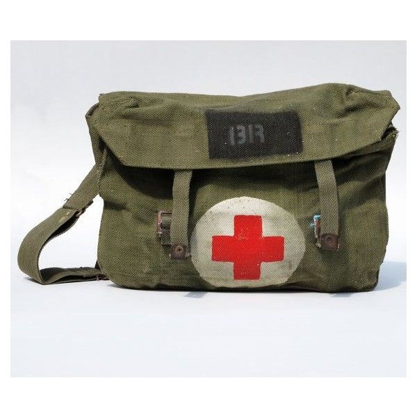 a worn canvas medical bag is displayed. the bag is green with a white circle and a red cross in the center. a strap is attached to the side. the number "1313" is stenciled in black on a patch at the top.