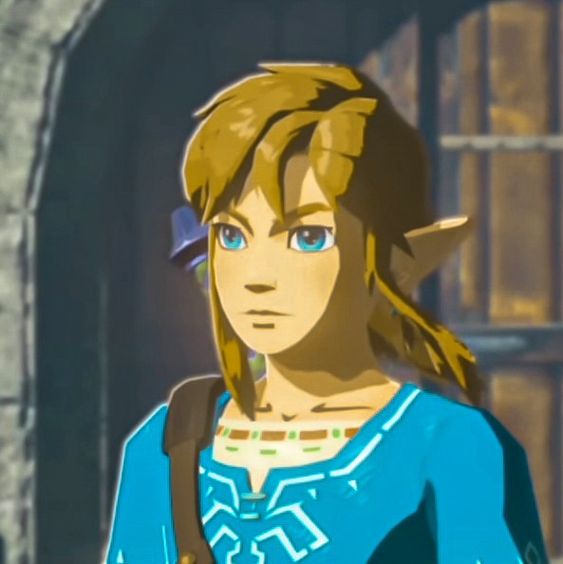 a closeup portrait of link from the video game legend of zelda: breath of the wild. he has short blonde hair, blue eyes, and is wearing his iconic blue tunic. he is standing in front of a stone wall with a blurred background.