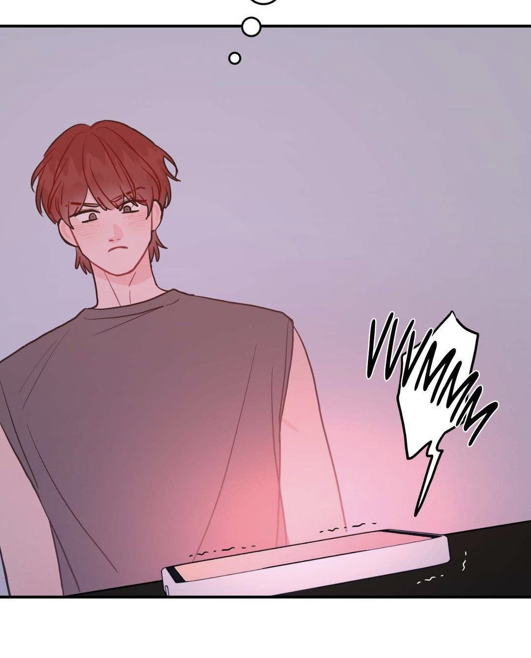 the image is a panel from a manhwa or webtoon, a style of korean comic. it features a young man with reddishbrown hair, wearing a sleeveless gray top. he has a slight blush on his cheeks and looks down at a phone lying on a surface in front of him. a speech bubble above the phone depicts a vibrating sound ("vvmmmm"). the overall color scheme is soft pinks and purples. the style is reminiscent of popular online romance comics, possibly in the bl (boys' love) genre. the focus is on the man's reaction to a phone notification.