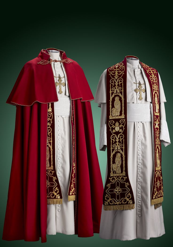 two mannequins are dressed in the traditional vestments of the pope. the one on the left wears a red cape called a "mozzetta" over a white cassock. the one on the right wears a white cassock and a red stole with gold embroidery. both mannequins wear a gold cross on their chest. the background is a dark green.