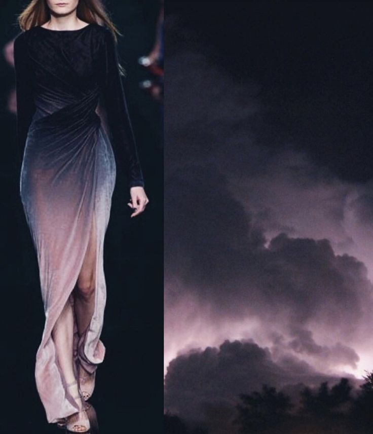 a woman in a black and ombre purple gown walks on a runway during a fashion show. the background is a dark sky with storm clouds, creating a dramatic and beautiful setting. the model's elegant pose and the dramatic lighting create a sense of glamour and mystery.