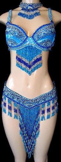a mannequin is wearing a blue belly dance costume with beads and sequins. the costume includes a bra, belt, and choker, all decorated with fringe.