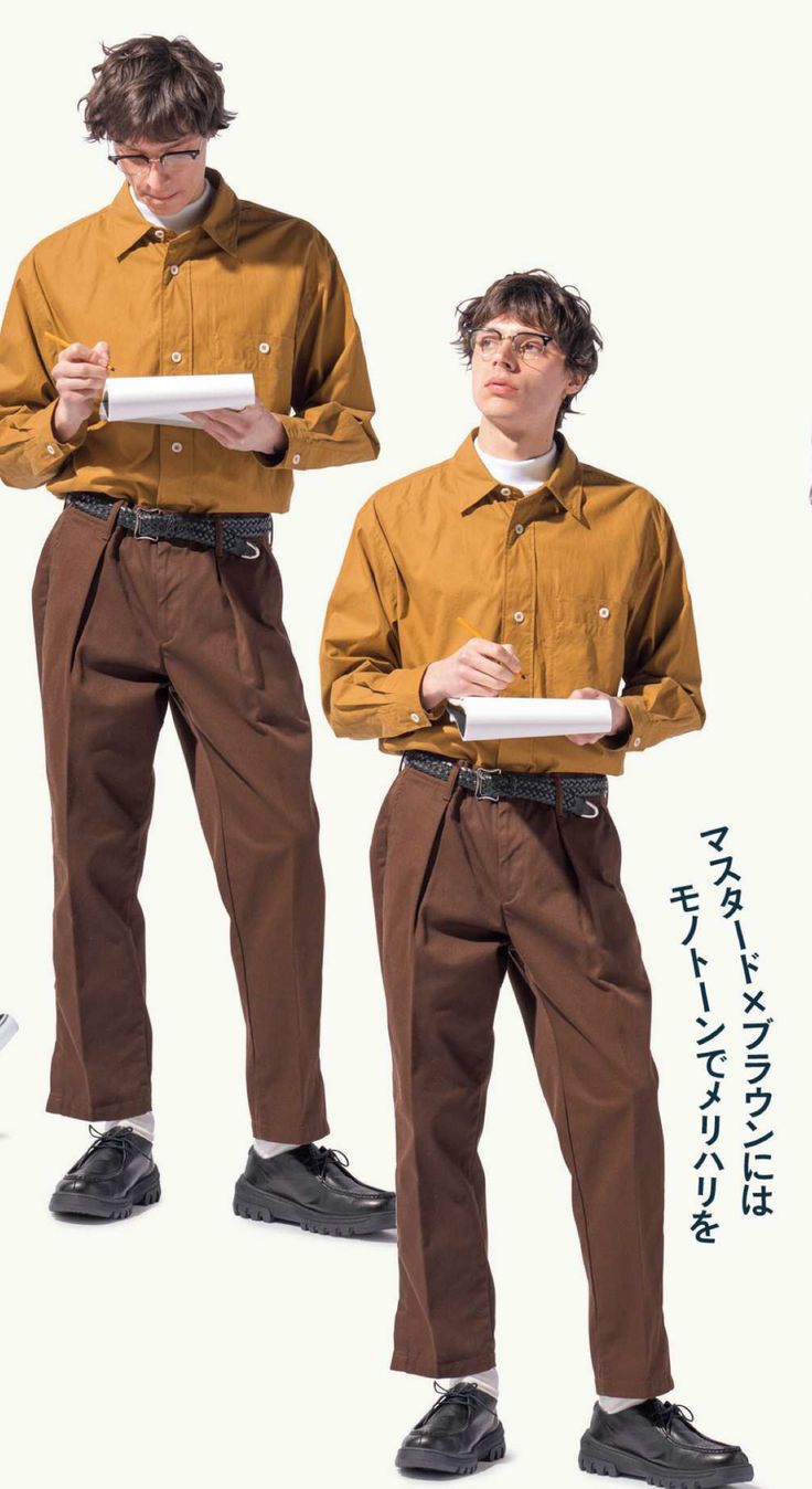 the image shows two men in similar outfits.  both are wearing a mustardcolored longsleeved shirt, brown pleated trousers, and darkcolored shoes. they both have on glasses and are holding notebooks, seemingly taking notes. one man is positioned slightly behind and to the side of the other, creating a mirrored effect. the background is plain white, focusing attention on the clothing and the men's poses. the overall style is reminiscent of vintage or retro workwear with a touch of modern minimalism.  japanese text is partially visible on the right side of the image.