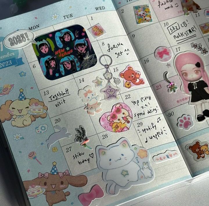 a cute and colorful calendar page with various stickers.  the stickers are in a variety of styles, including kawaii, anime, and aesthetic. there are stickers of animals, food, and flowers.  the calendar is decorated with pastel colors and features a blue and white background with light blue and white grid lines. the calendar has a small amount of text handwritten on it. the calendar is set up with the month of december and the year 2023. the month is highlighted with bright colors.