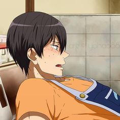 the image showcases a closeup of a young man with short, dark hair and flushed cheeks. he appears slightly flustered and sweaty, his expression suggesting surprise or embarrassment. he is wearing an orange tshirt and a blue apron, indicating he may be engaged in cooking or housework. the setting appears to be a kitchen, evident from the tiled wall and glimpse of shelves in the background. the lighting is soft and natural, creating a gentle atmosphere.