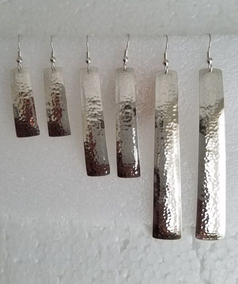 five pairs of silver hammered rectangular earrings of different lengths are displayed on a white background. the earrings are arranged in order from shortest to longest.
