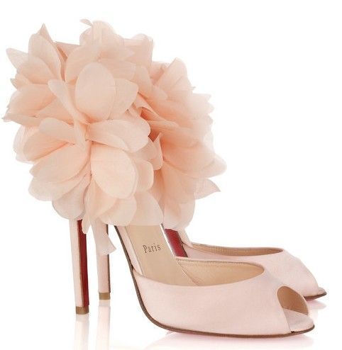a pair of pink christian louboutin peeptoe high heels are featured in the image. the shoes are adorned with large, fluffy floral embellishments, and the heels are red. one shoe has the word "paris" on the inner side.