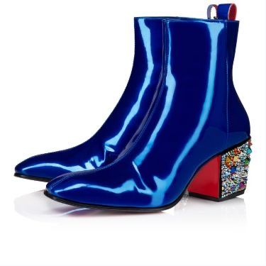 two blue patent leather ankle boots with pointed toes and jeweled heels are shown on a white surface. the heels are red and decorated with colorful jewels. the boots have a shiny appearance.