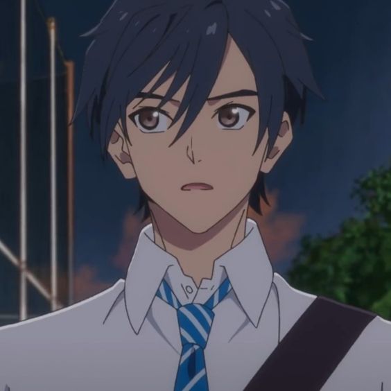 a young, animated male with dark blue hair and brown eyes is shown from the shoulders up. he is wearing a white shirt with a blue and white striped tie and a dark blue shoulder bag. he has a concerned expression on his face, with his eyebrows slightly furrowed and his mouth slightly open. the background is dark and blurry, suggesting a nighttime setting. the overall lighting is dim.