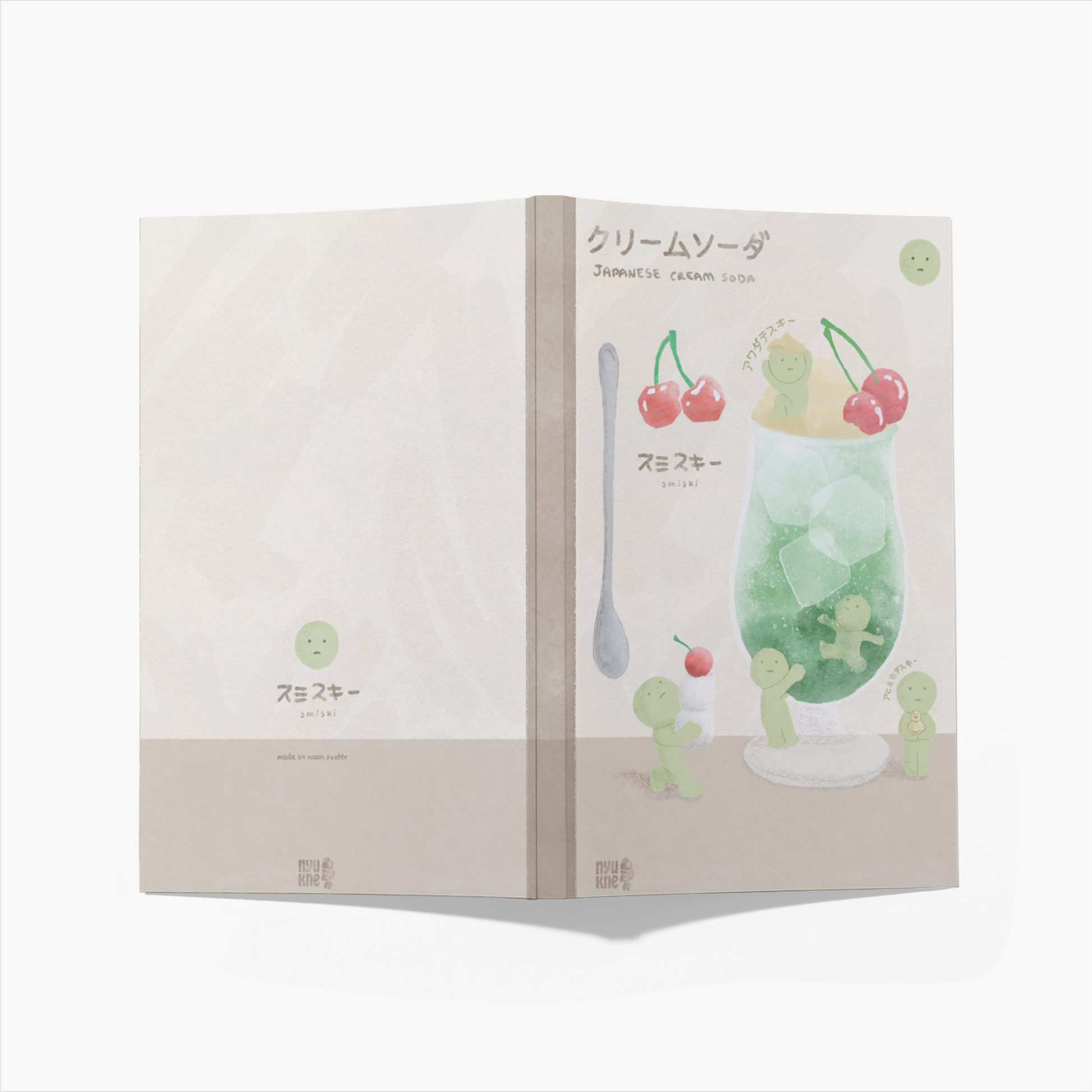 he image shows a closed notebook or sketchbook with a design featuring a japanese cream soda. the front cover displays a simple illustration of a sadfaced character, and the back cover showcases a detailed watercolor painting of a cream soda with cherries and cute little characters interacting with it.  the japanese name for cream soda ("クリームソーダ") and the english translation are written on the back cover, along with the word "smizi" under a character illustration. the overall style is kawaii (cute) and pasteltoned, suggesting a design aimed at a younger audience or those who appreciate cute aesthetics. the notebook appears to be made of a soft, textured material, with the pages showing a slight curve.