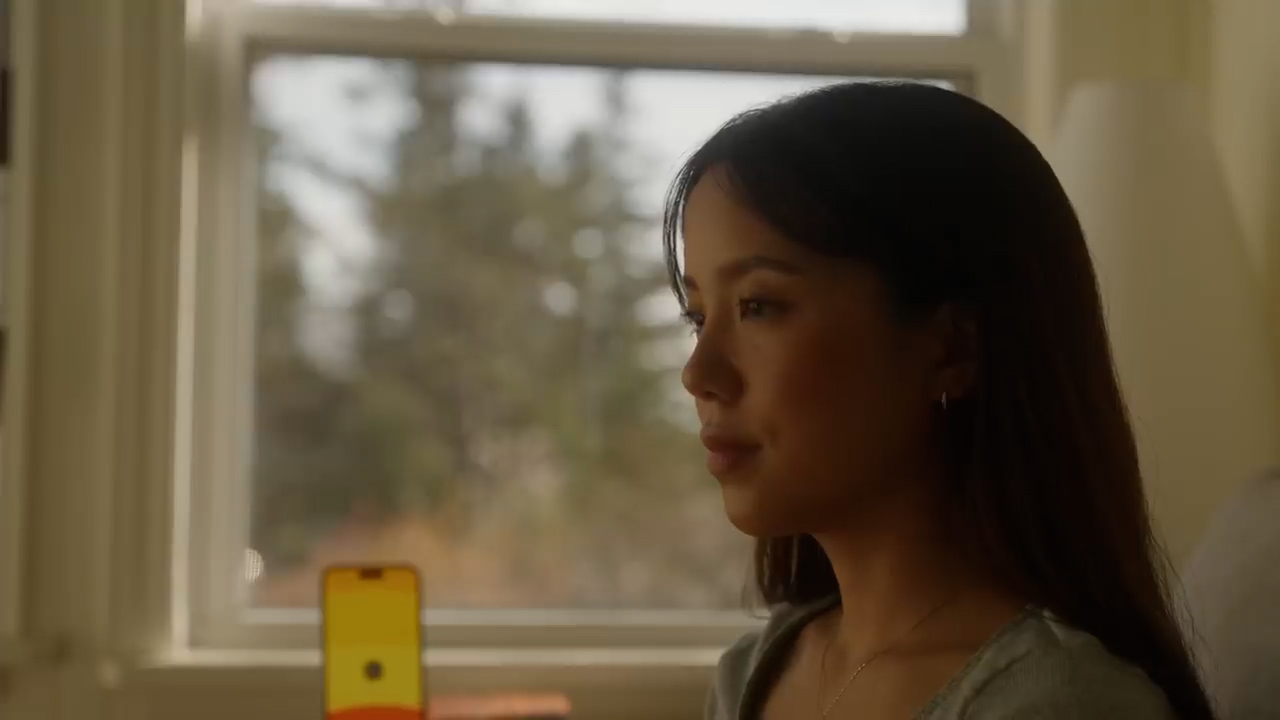 the image shows a young woman sitting in profile, her face illuminated by soft, natural light streaming through a window. the warm light highlights her features as she gazes thoughtfully out of frame, her expression serene and introspective. the background is slightly out of focus, drawing attention to the woman's contemplative state. the overall mood of the image is calm, peaceful, and introspective.