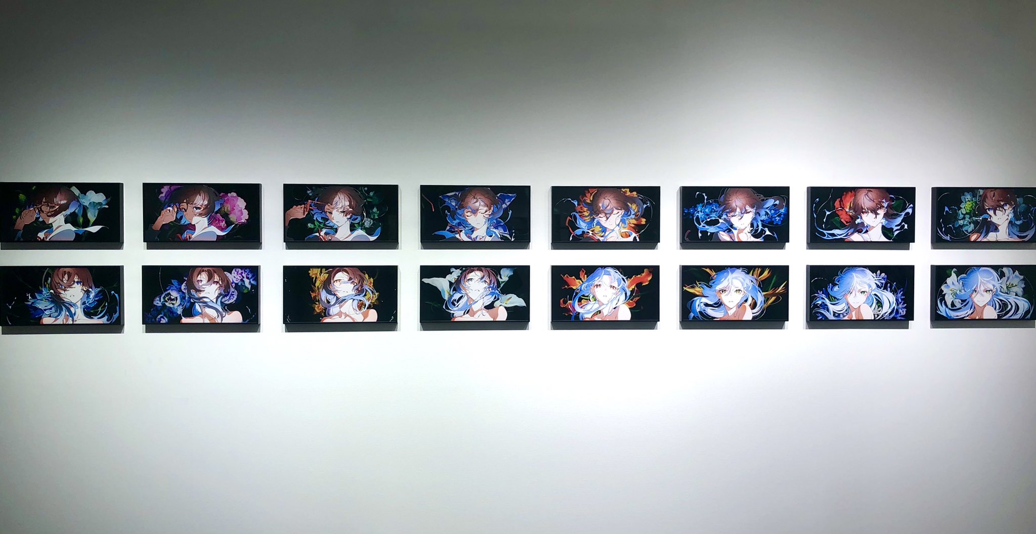 sixteen digital artworks are displayed in a fourbyfour grid on a white wall, each illuminated by a spotlight. each piece features a female anime character with flowing blue hair, set against a vibrant backdrop of abstract shapes and patterns in shades of blue, green, and orange. the overall effect is striking and immersive.