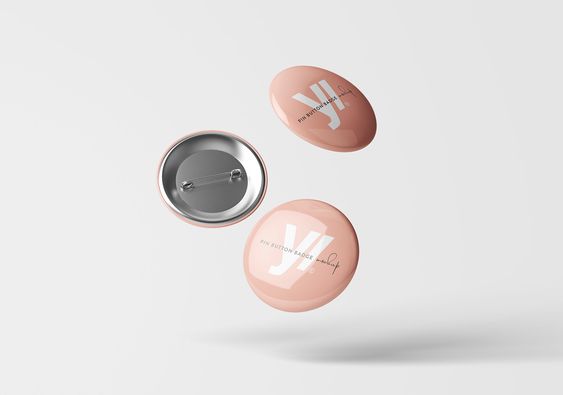 this image contains three round pin button badge mockups with a front and side view. the badges are a light pink color with a white inscription. they are shown against a white background with their shadows visible below.
