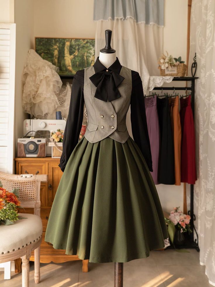 a vintageinspired dress is displayed on a mannequin. the dress features a green, full skirt and a grey vest with a black bowtie.  the mannequin stands in a room with vintage furniture and decor. the image is lit with soft, indoor lighting and taken from an eyelevel perspective.