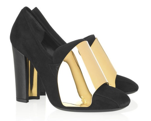 a pair of elegant black suede high heels are shown.  the heels feature a chunky block heel with gold metal accents on the sides and extending up to the vamp of the shoe, creating a unique design element.  the shoes appear to be made of highquality materials and have a sophisticated and stylish look suitable for formal occasions or special events.