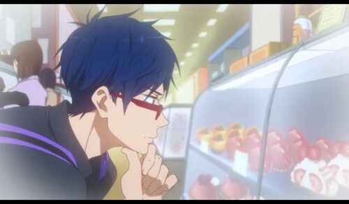 a closeup of an anime boy with blue hair and red glasses, looking thoughtfully to his side. he is standing in a bakery, the counter is full of sweet desserts, and there are other people in the background.