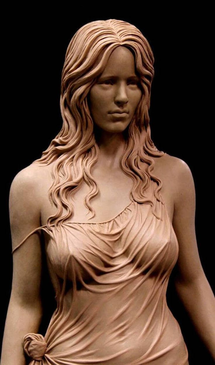 the image showcases a stunningly realistic clay sculpture of a woman's upper body. the sculpture captures the subject's delicate features and the flow of her hair with incredible detail. she is wearing a loosely draped, sleeveless dress that reveals the curves of her form. the sculpture appears to be set against a plain black background, highlighting the artistry and craftsmanship of the piece.